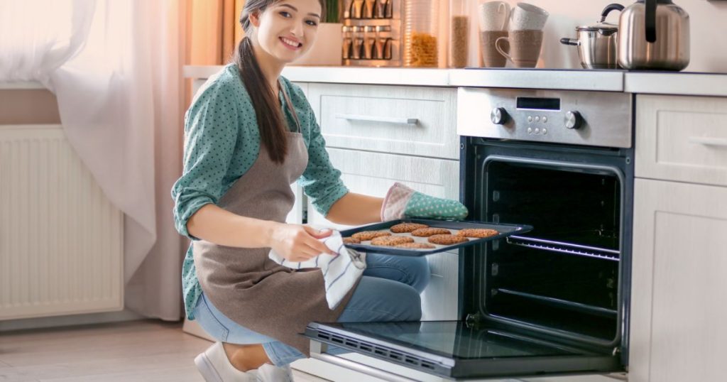 woman baking cookies in oven