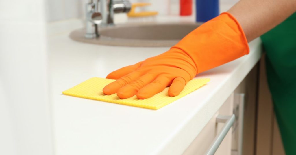 woman cleaning kitchen countertop
with rag